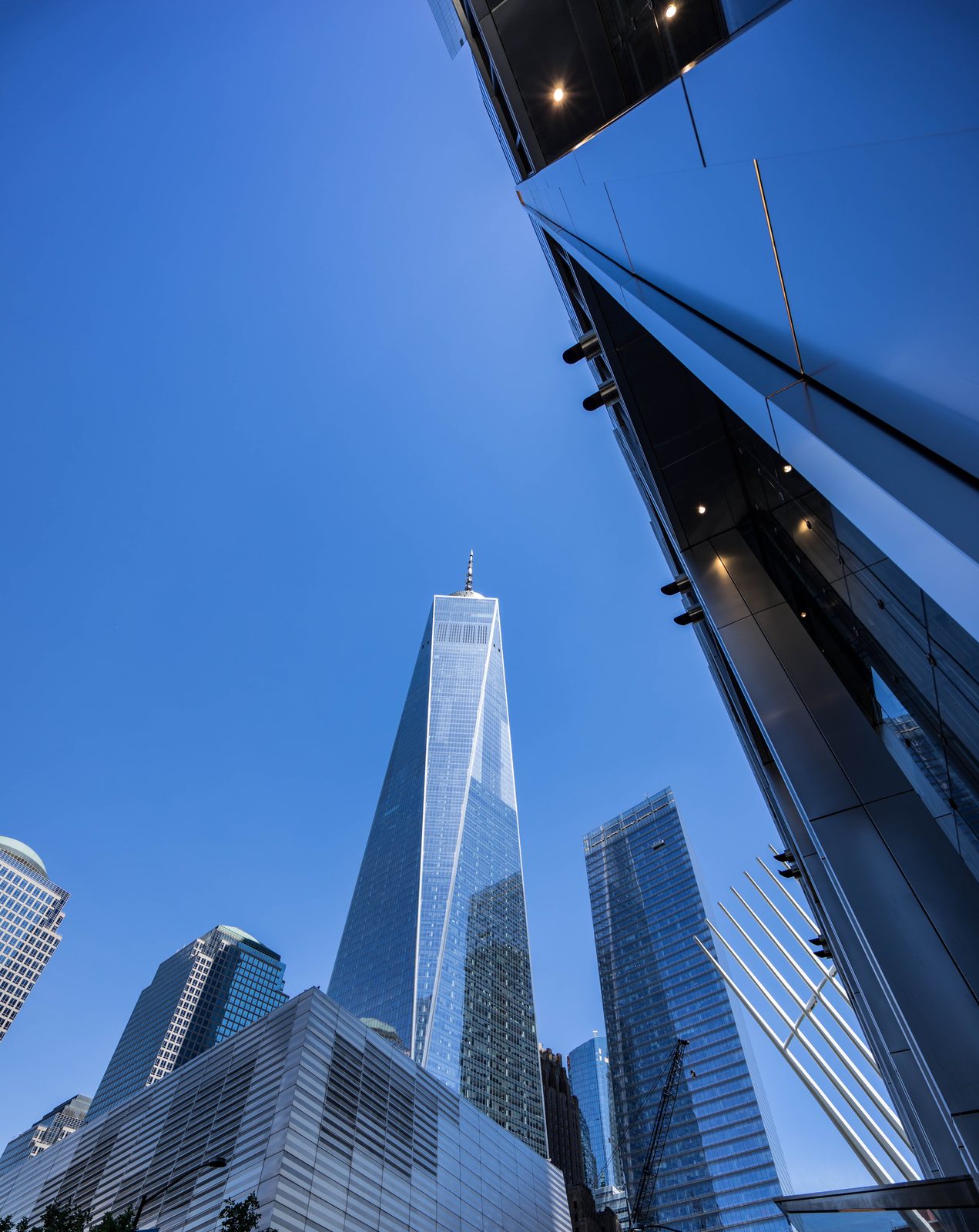 One World Trade Center seen from below between mirrored glass towers